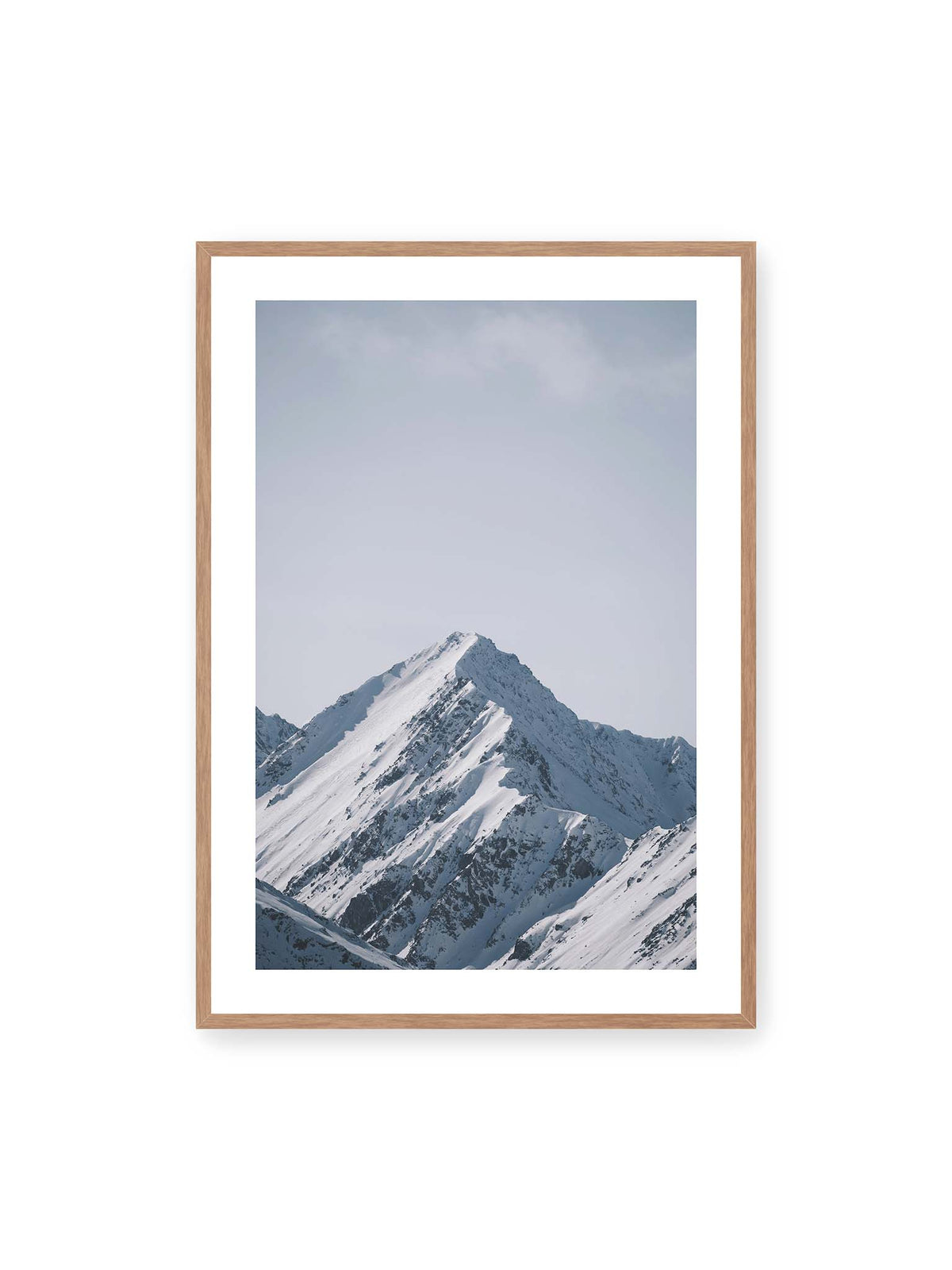 70x100 cm, weißer Galerie-Rand, Eichenrahmen – Schneebedeckter Berggipfel mit steilen Graten vor einem weiten blassblauen Himmel.