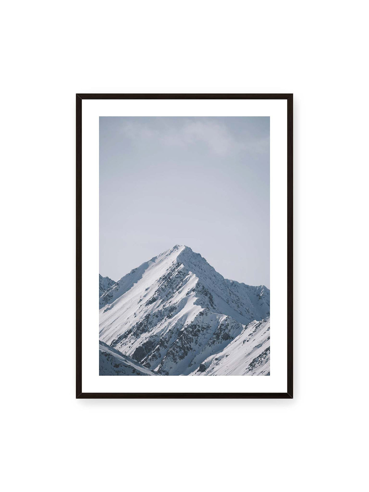 70x100 cm, weißer Galerie-Rand, schwarzer Rahmen – Schneebedeckter Berggipfel mit steilen Graten vor einem weiten blassblauen Himmel.