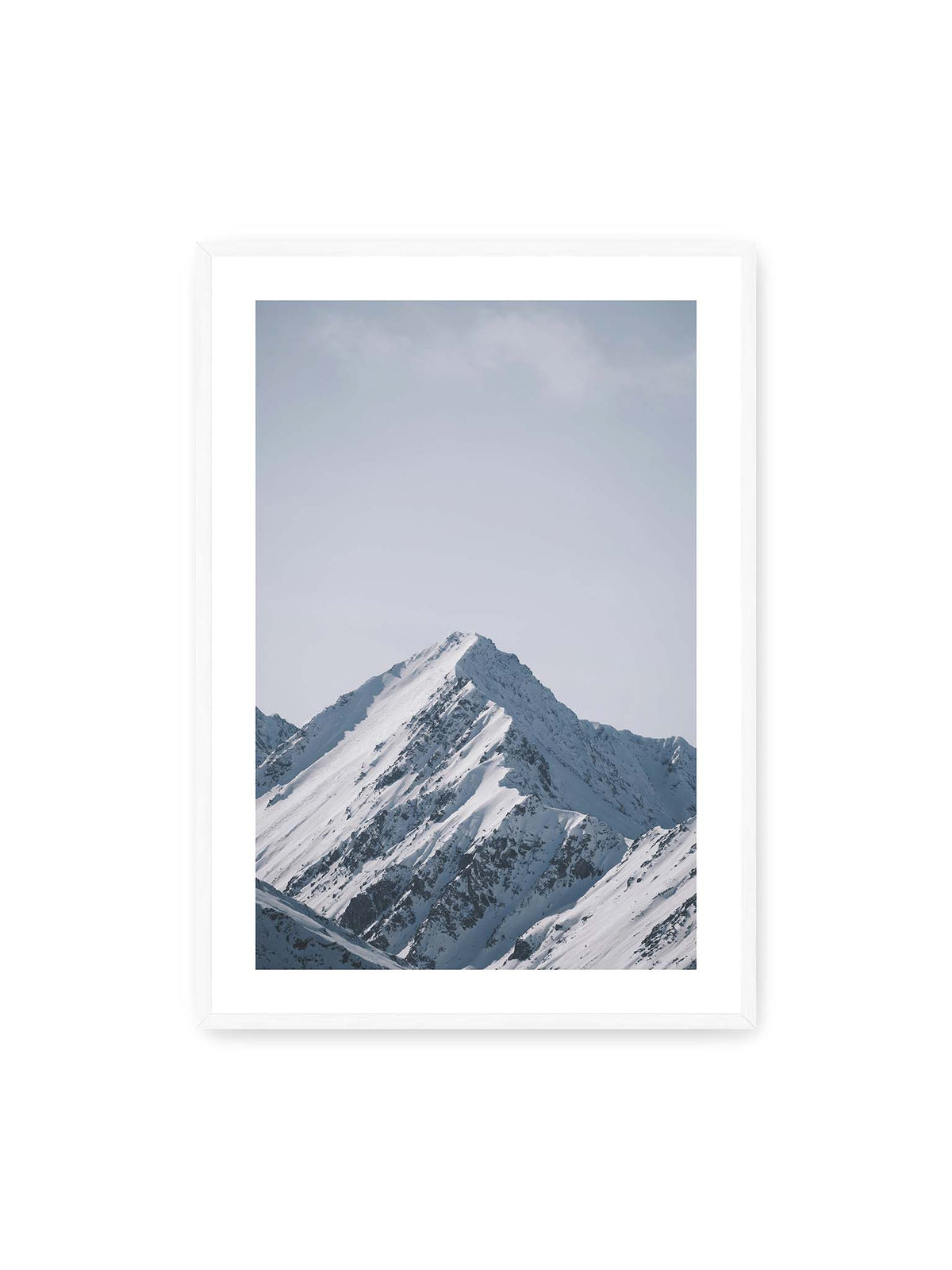70x100 cm, weißer Galerie-Rand, weißer Rahmen – Schneebedeckter Berggipfel mit steilen Graten vor einem weiten blassblauen Himmel.