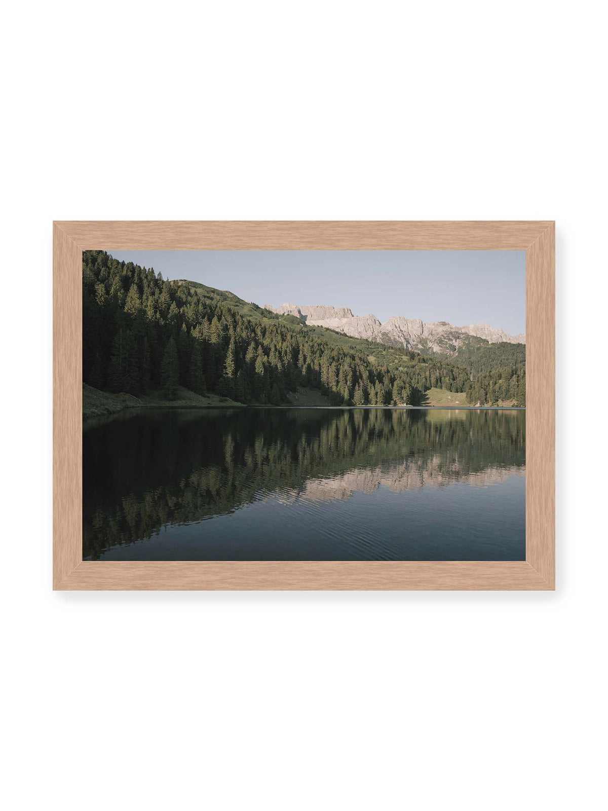 30x21 cm, Eichenrahmen – Ruhiger Bergsee mit Spiegelungen von bewaldeten Hängen und einer hellen Felskette unter blauem Himmel.