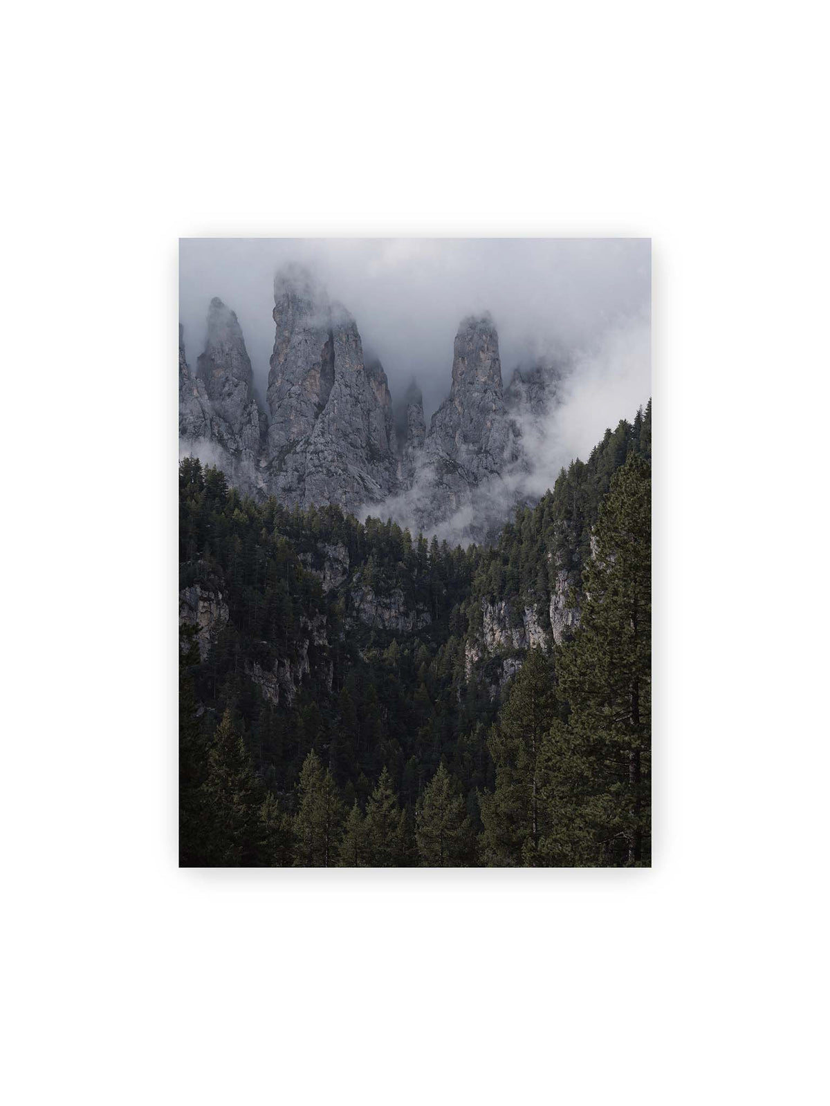 30x40 cm – Steile graue Felstürme zwischen tiefen Wolken über einem dicht bewachsenen dunklen Nadelwald.