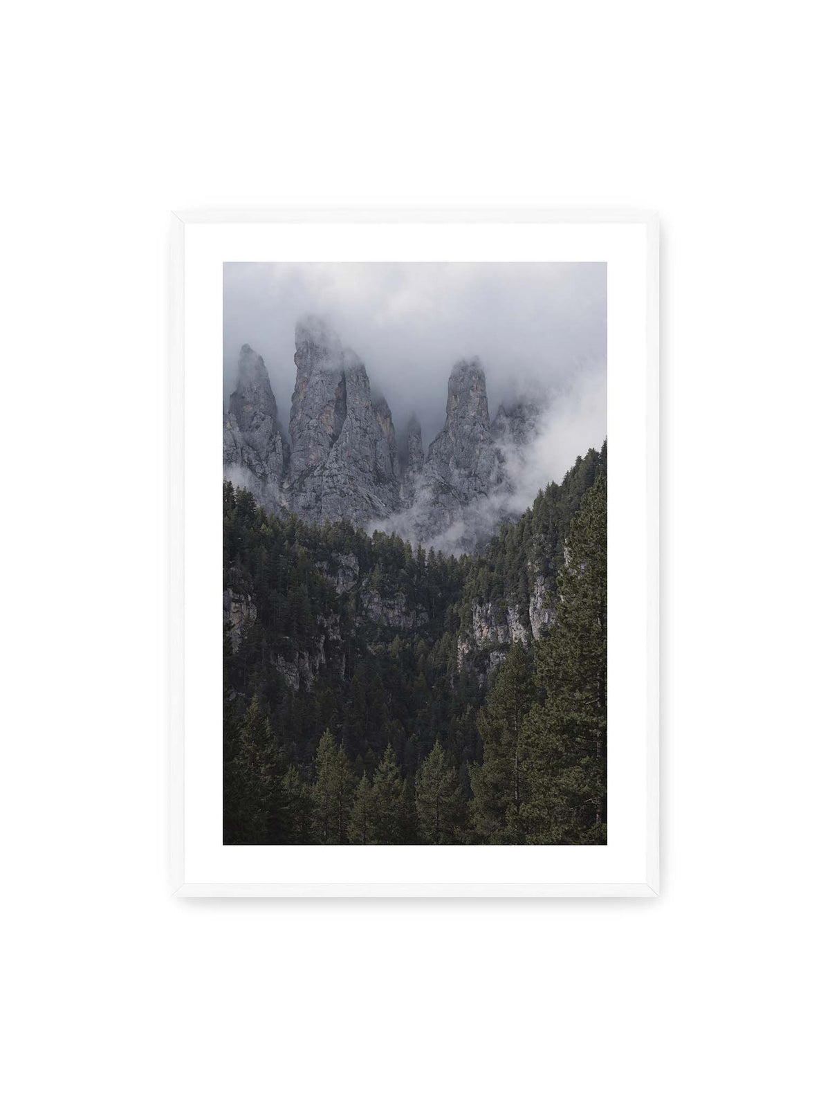 70x100 cm, weißer Galerie-Rand, weißer Rahmen – Steile graue Felstürme zwischen tiefen Wolken über einem dicht bewachsenen dunklen Nadelwald.
