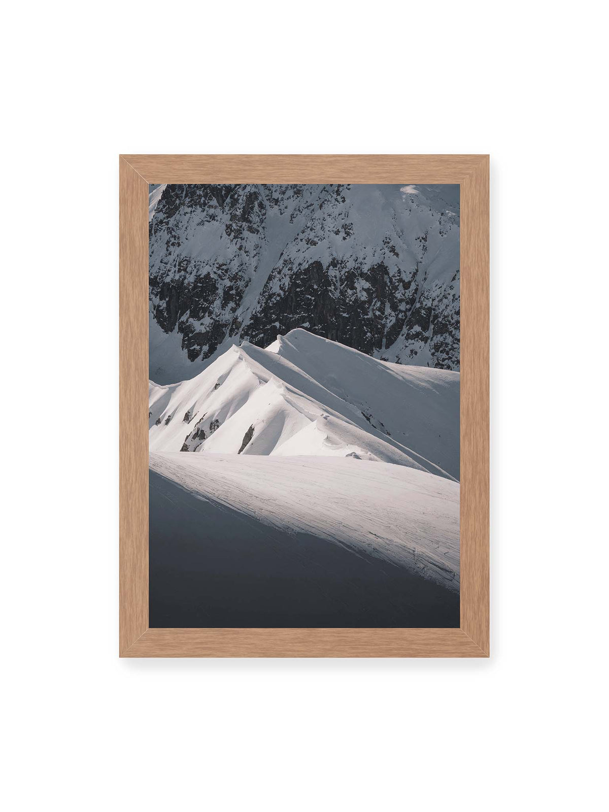 21x30 cm, Eichenrahmen – Schneebedeckte Berggrate mit scharfen Kämmen und tiefen Schatten vor einer dunklen felsigen Bergwand.