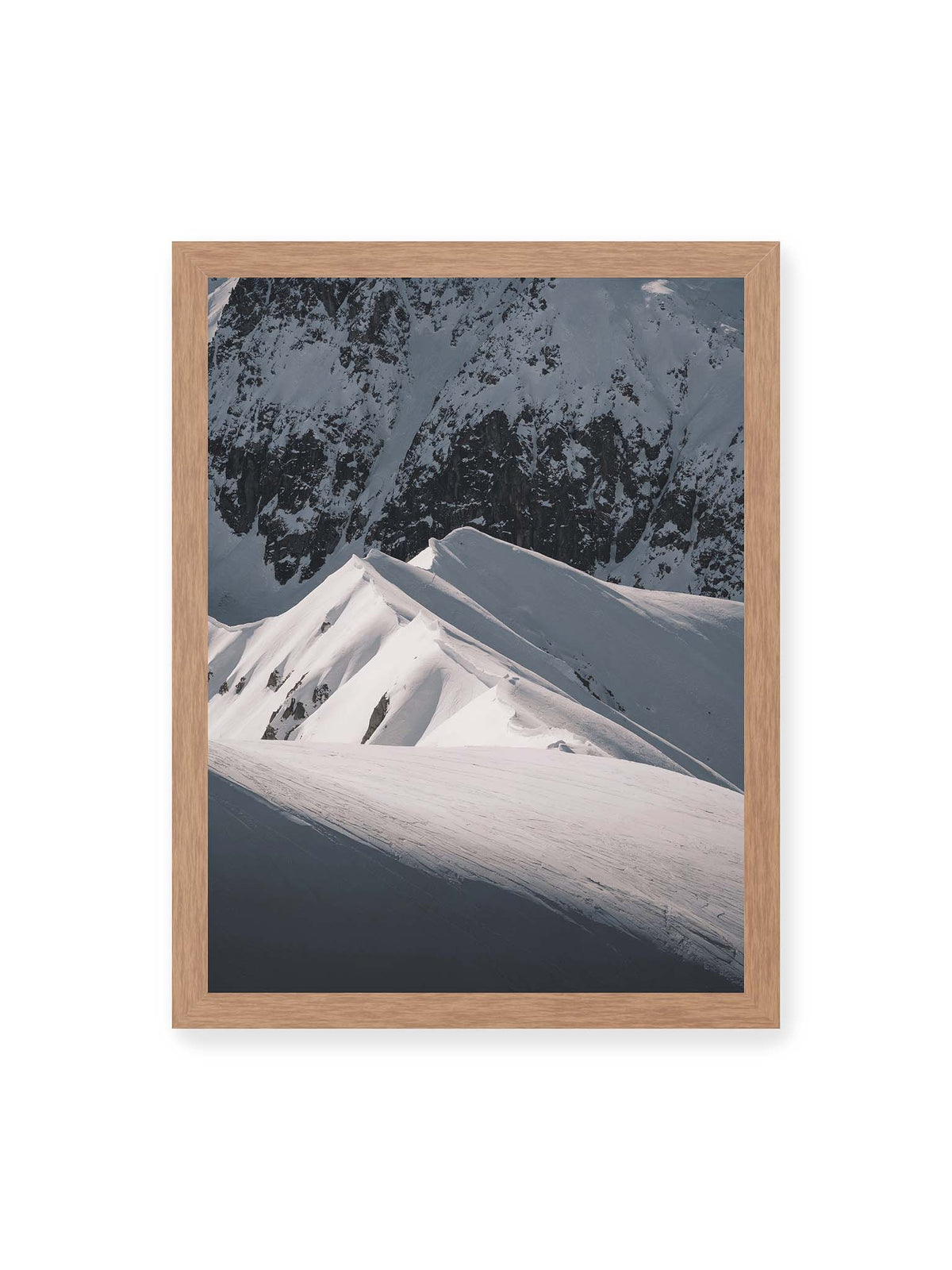 30x40 cm, Eichenrahmen – Schneebedeckte Berggrate mit scharfen Kämmen und tiefen Schatten vor einer dunklen felsigen Bergwand.
