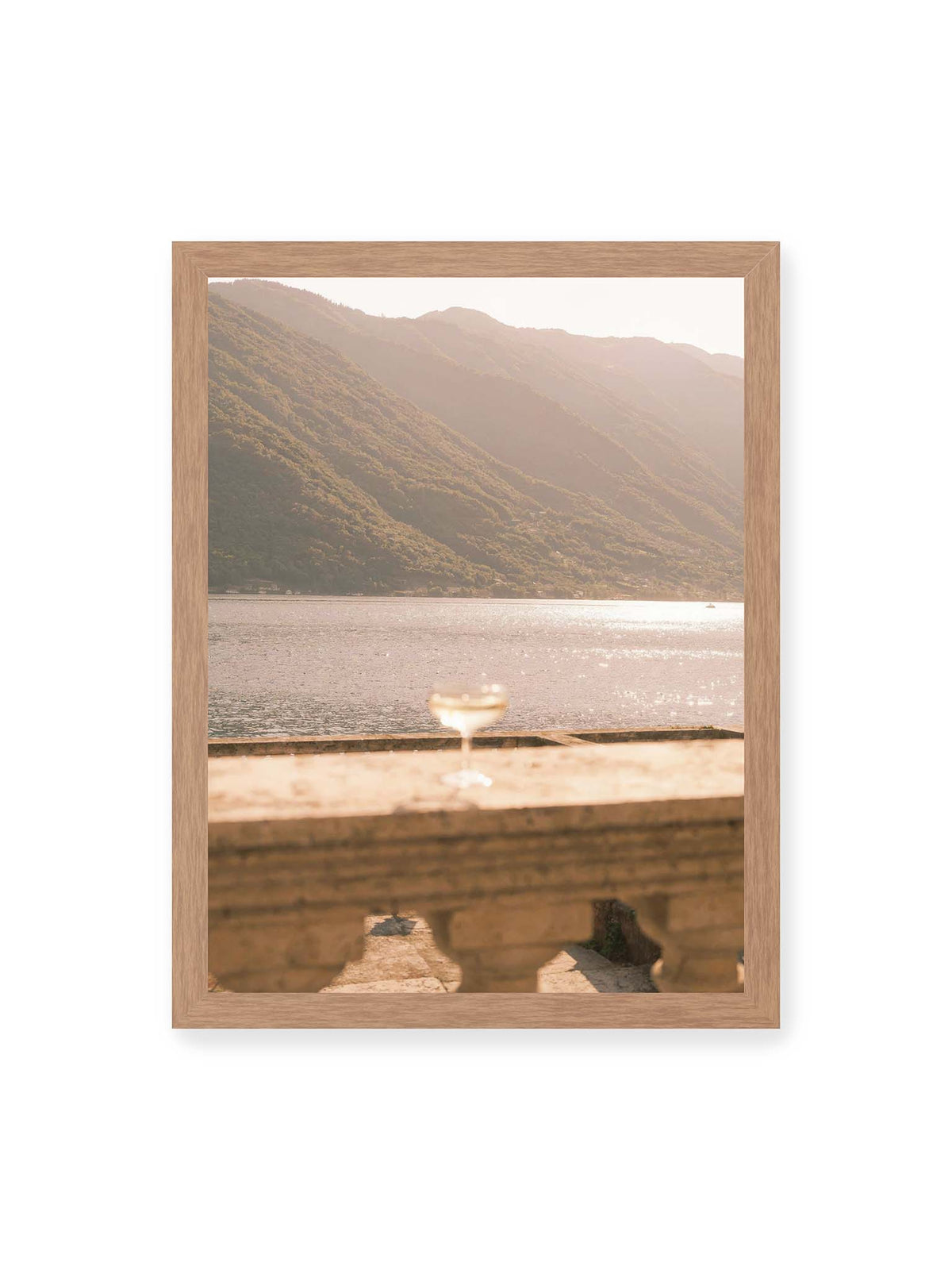 30x40 cm, Eichenrahmen – Einzelnes Glas auf heller Steinfläche vor glitzerndem Wasser und bewaldeten Berghängen.