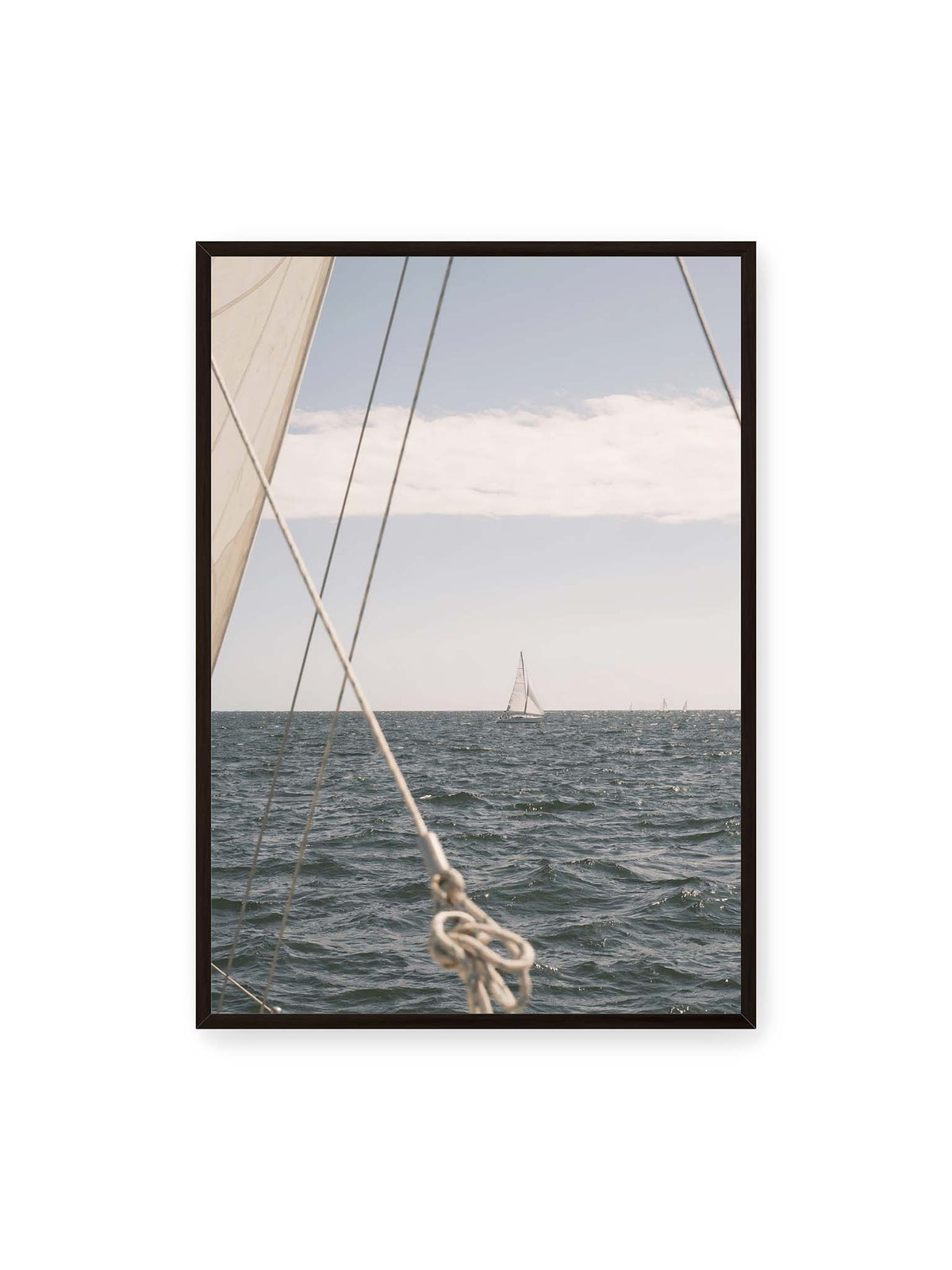 70x100 cm, schwarzer Rahmen – Segelboot auf bewegtem Wasser, eingerahmt von hellem Segel und diagonalen Leinen im Vordergrund.