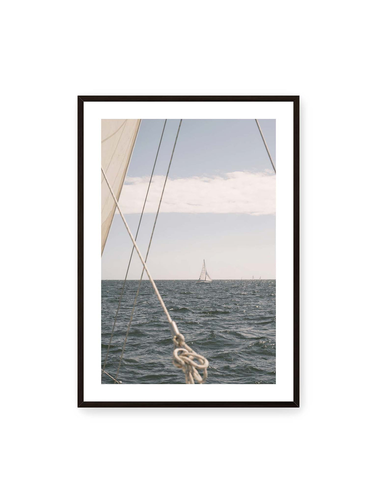 70x100 cm, weißer Galerie-Rand, schwarzer Rahmen – Segelboot auf bewegtem Wasser, eingerahmt von hellem Segel und diagonalen Leinen im Vordergrund.