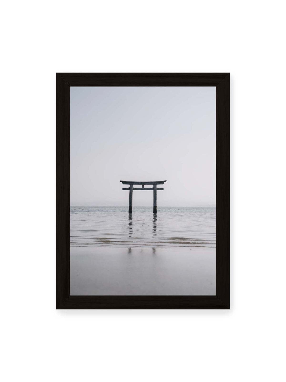 21x30 cm, schwarzer Rahmen – Dunkles Torii im ruhigen Wasser vor hellem Horizont mit sanfter Spiegelung und feinen Wellen.