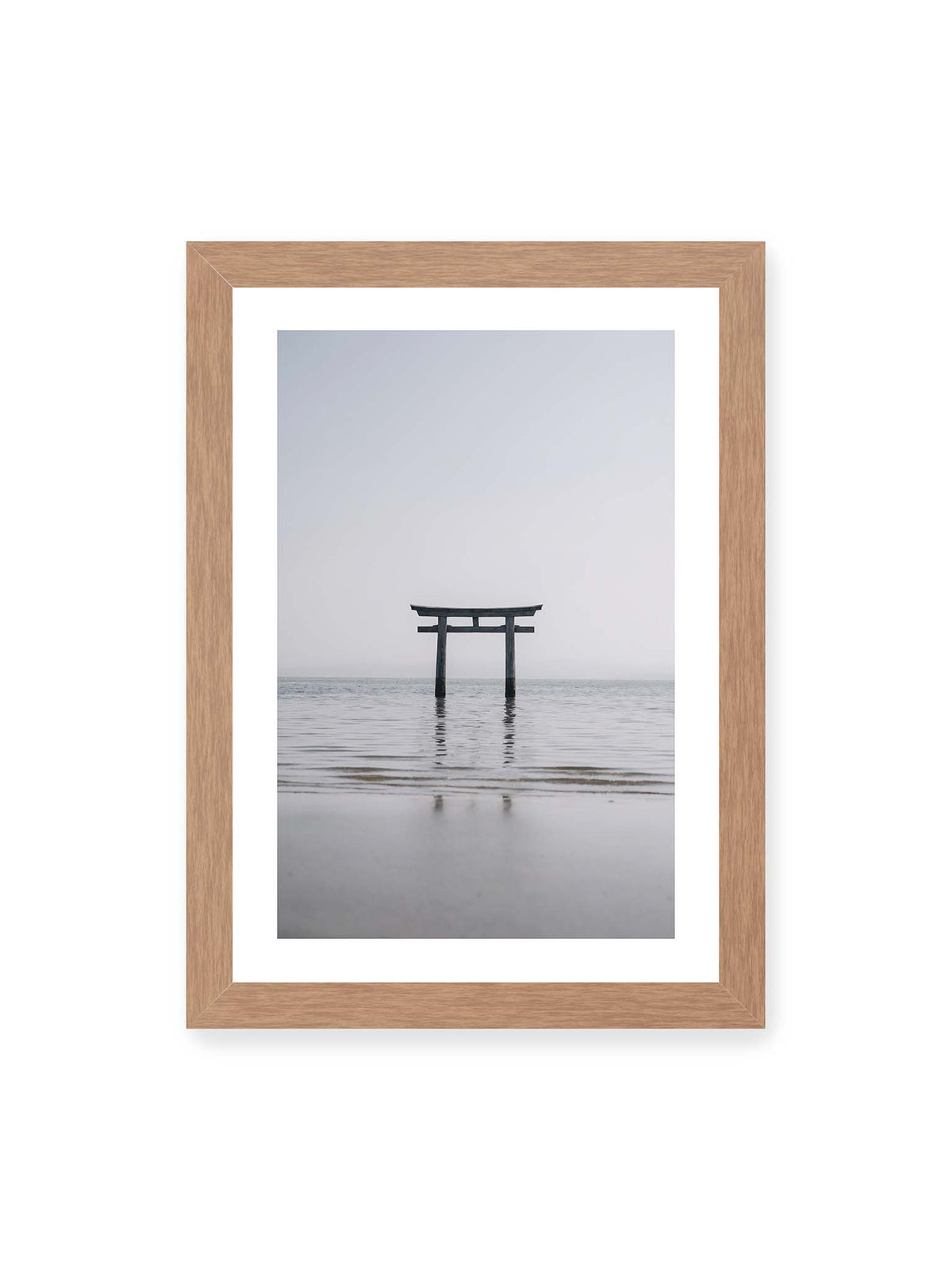 21x30 cm, weißer Galerie-Rand, Eichenrahmen – Dunkles Torii im ruhigen Wasser vor hellem Horizont mit sanfter Spiegelung und feinen Wellen.