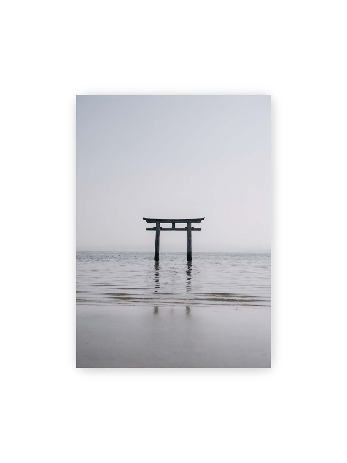 50x70 cm – Dunkles Torii im ruhigen Wasser vor hellem Horizont mit sanfter Spiegelung und feinen Wellen.