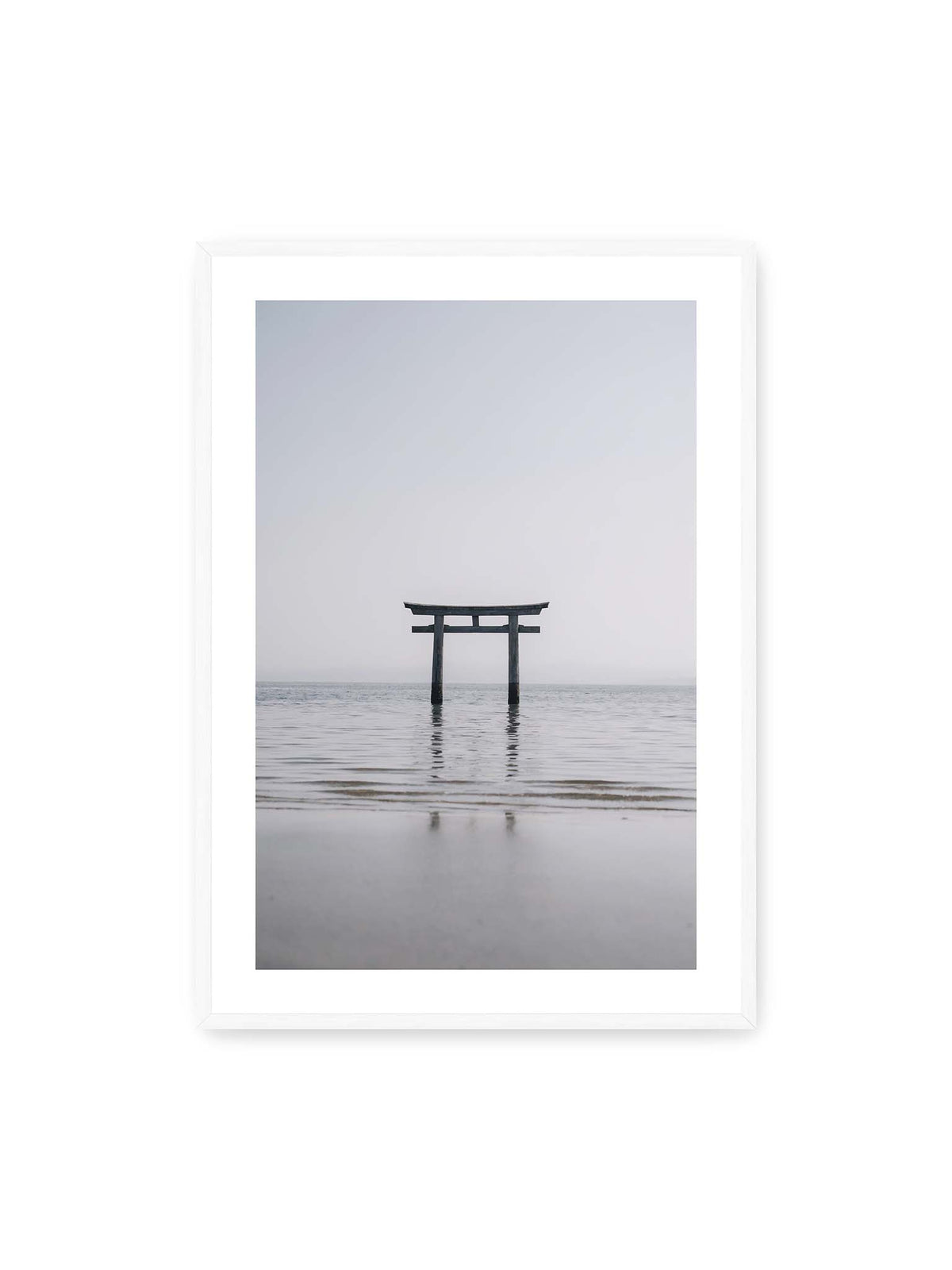 70x100 cm, weißer Galerie-Rand, weißer Rahmen – Dunkles Torii im ruhigen Wasser vor hellem Horizont mit sanfter Spiegelung und feinen Wellen.