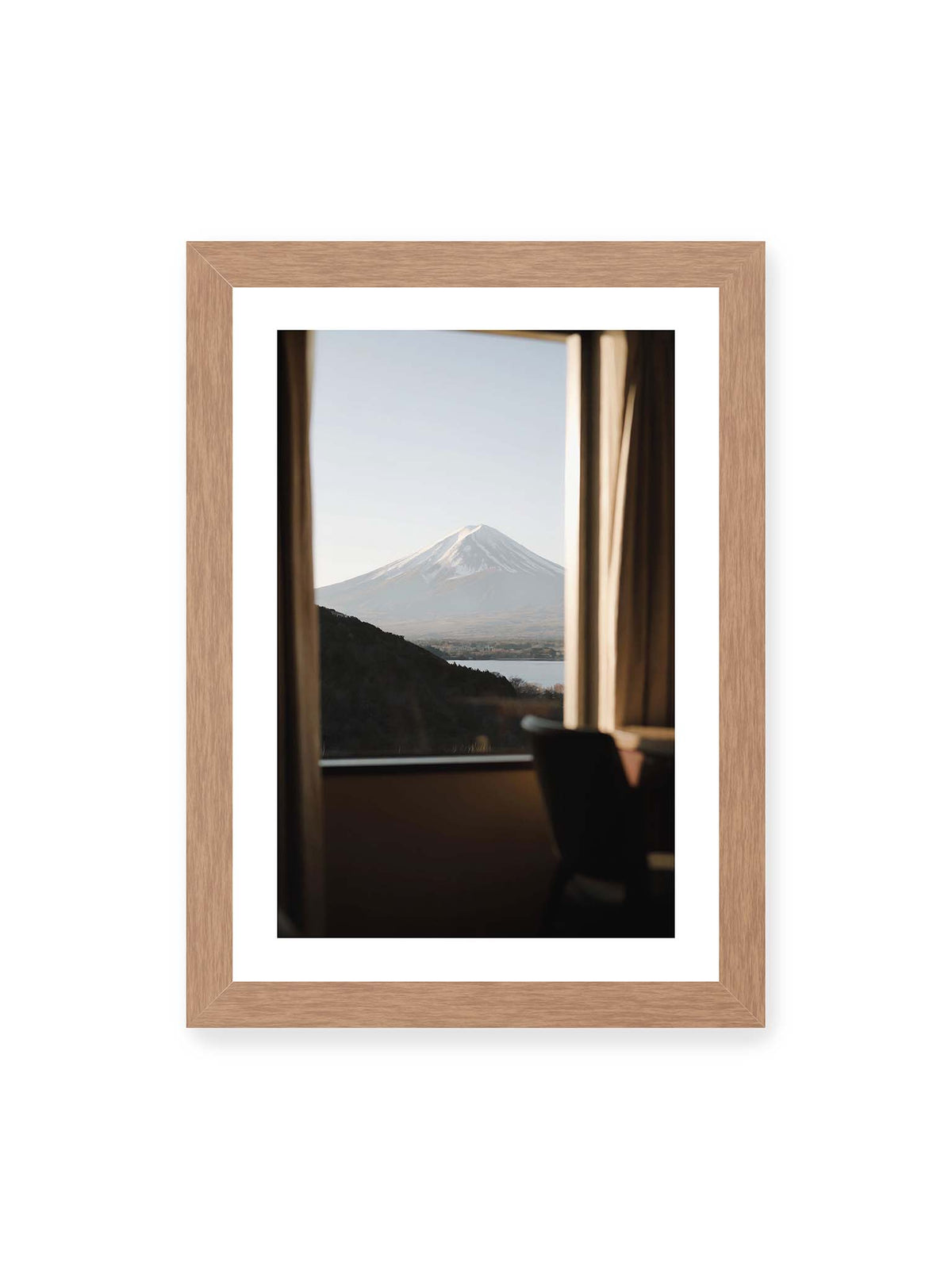 21x30 cm, weißer Galerie-Rand, Eichenrahmen – Schneebedeckter Mount Fuji durch ein großes Fenster, eingerahmt von Vorhängen und dunklen Elementen des Innenraums.