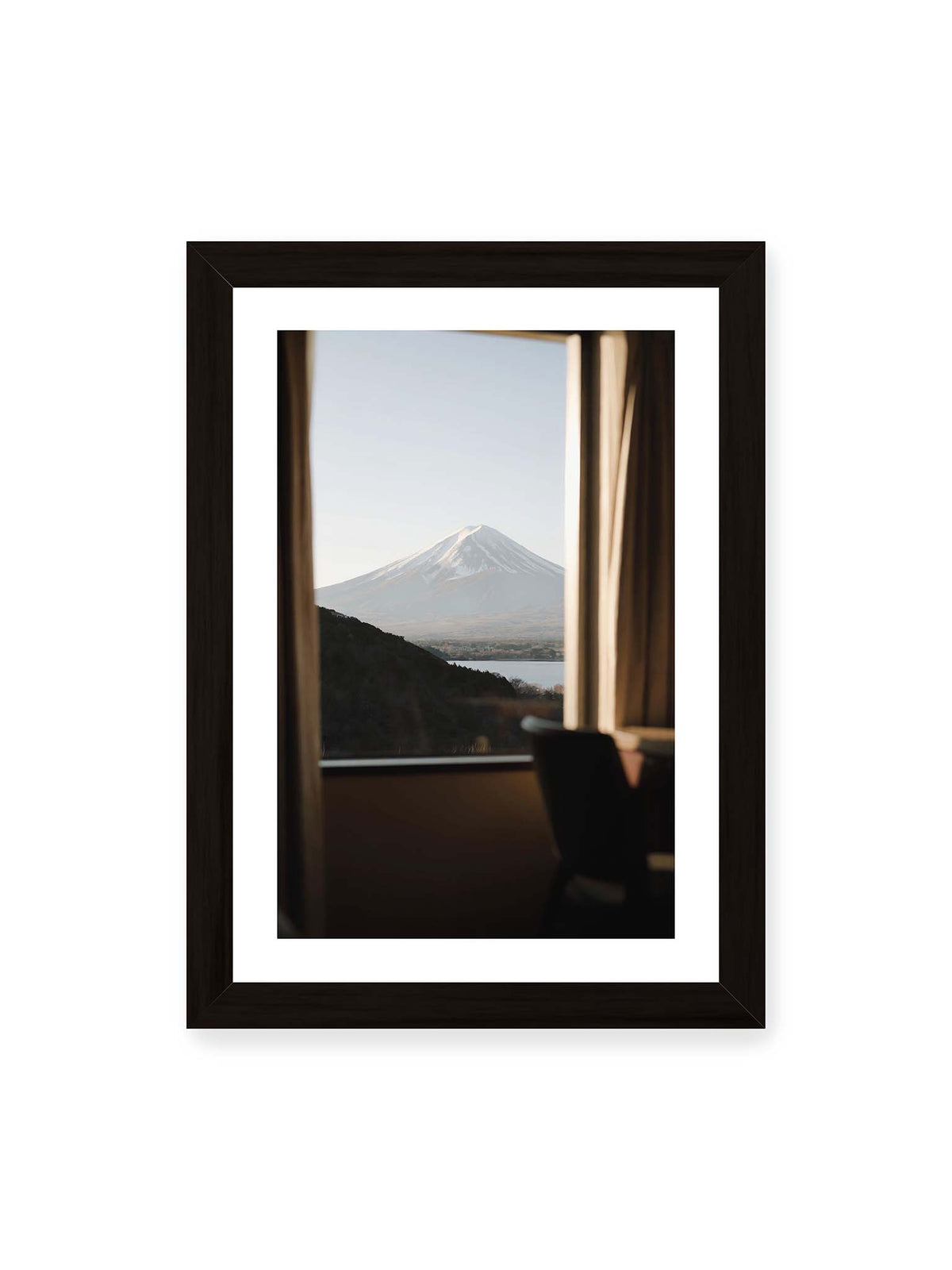 21x30 cm, weißer Galerie-Rand, schwarzer Rahmen – Schneebedeckter Mount Fuji durch ein großes Fenster, eingerahmt von Vorhängen und dunklen Elementen des Innenraums.