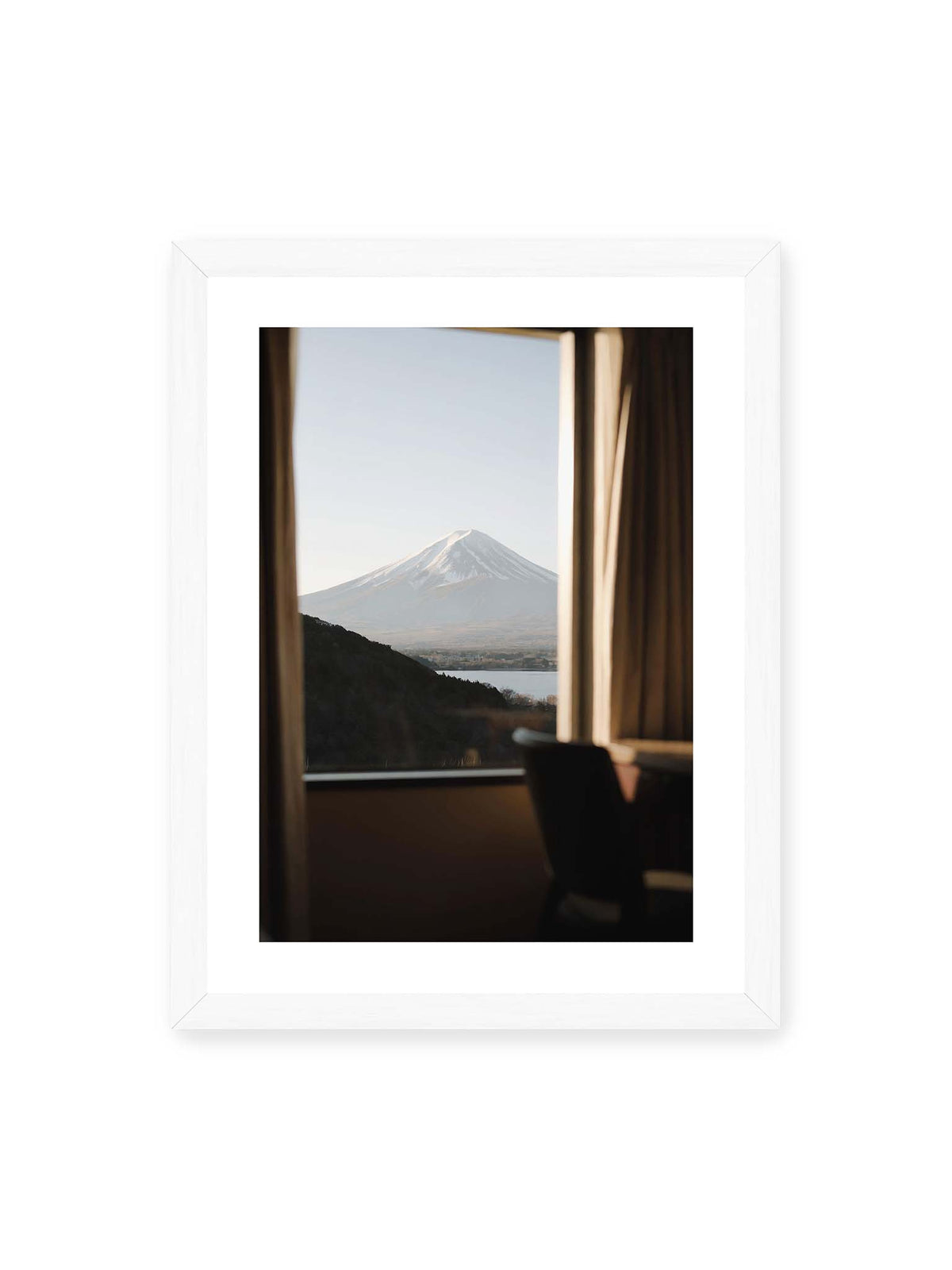 30x40 cm, weißer Galerie-Rand, weißer Rahmen – Schneebedeckter Mount Fuji durch ein großes Fenster, eingerahmt von Vorhängen und dunklen Elementen des Innenraums.