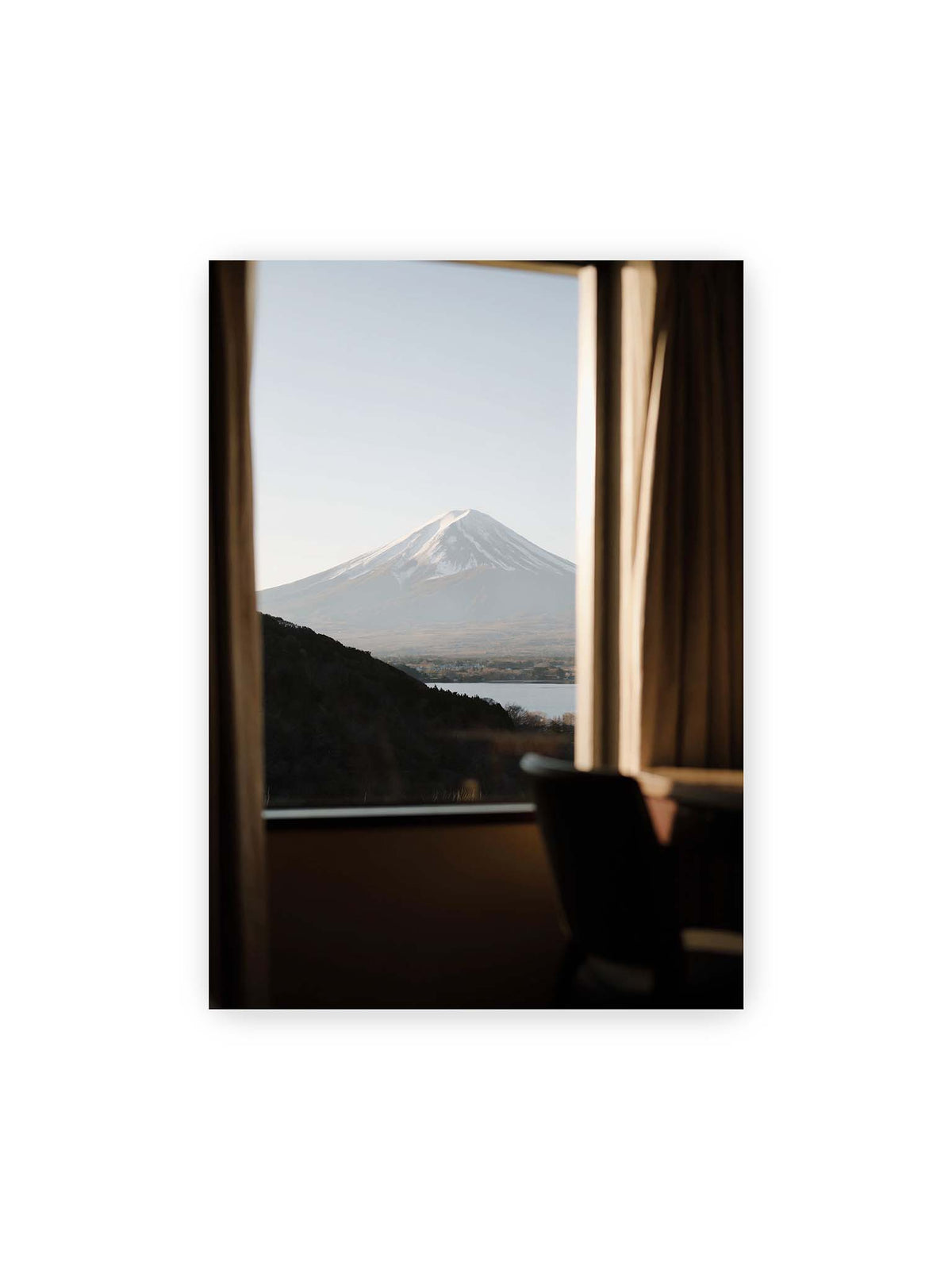 50x70 cm – Schneebedeckter Mount Fuji durch ein großes Fenster, eingerahmt von Vorhängen und dunklen Elementen des Innenraums.