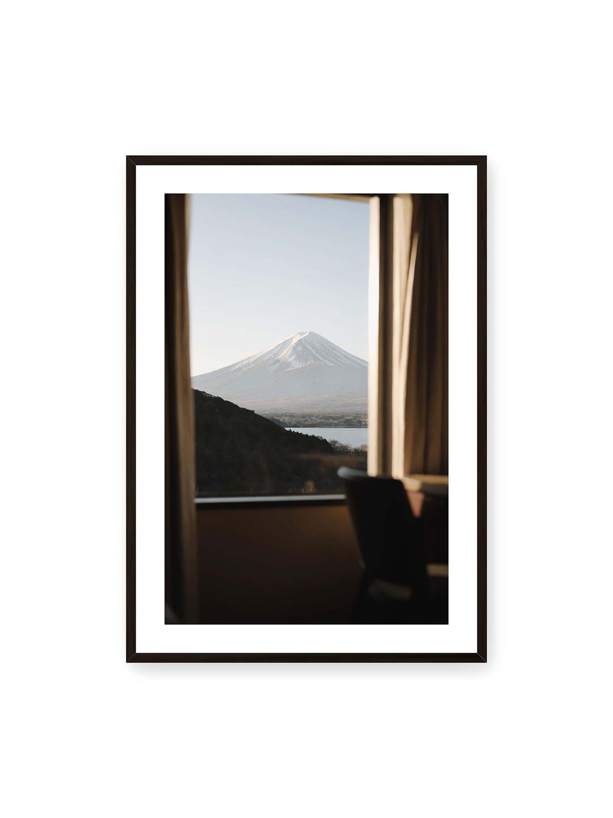 70x100 cm, weißer Galerie-Rand, schwarzer Rahmen – Schneebedeckter Mount Fuji durch ein großes Fenster, eingerahmt von Vorhängen und dunklen Elementen des Innenraums.