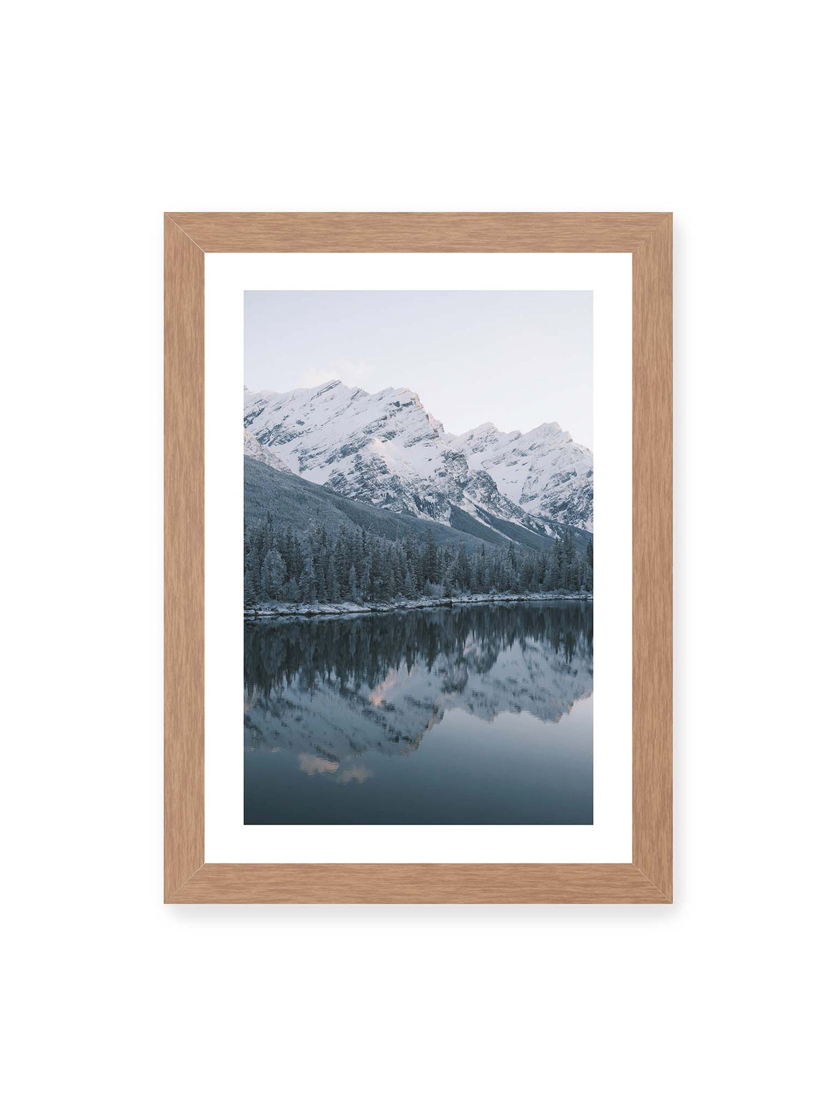 21x30 cm, weißer Galerie-Rand, Eichenrahmen – Verschneite Berggipfel und dichter Nadelwald spiegeln sich in einem ruhigen, blaugrauen See.