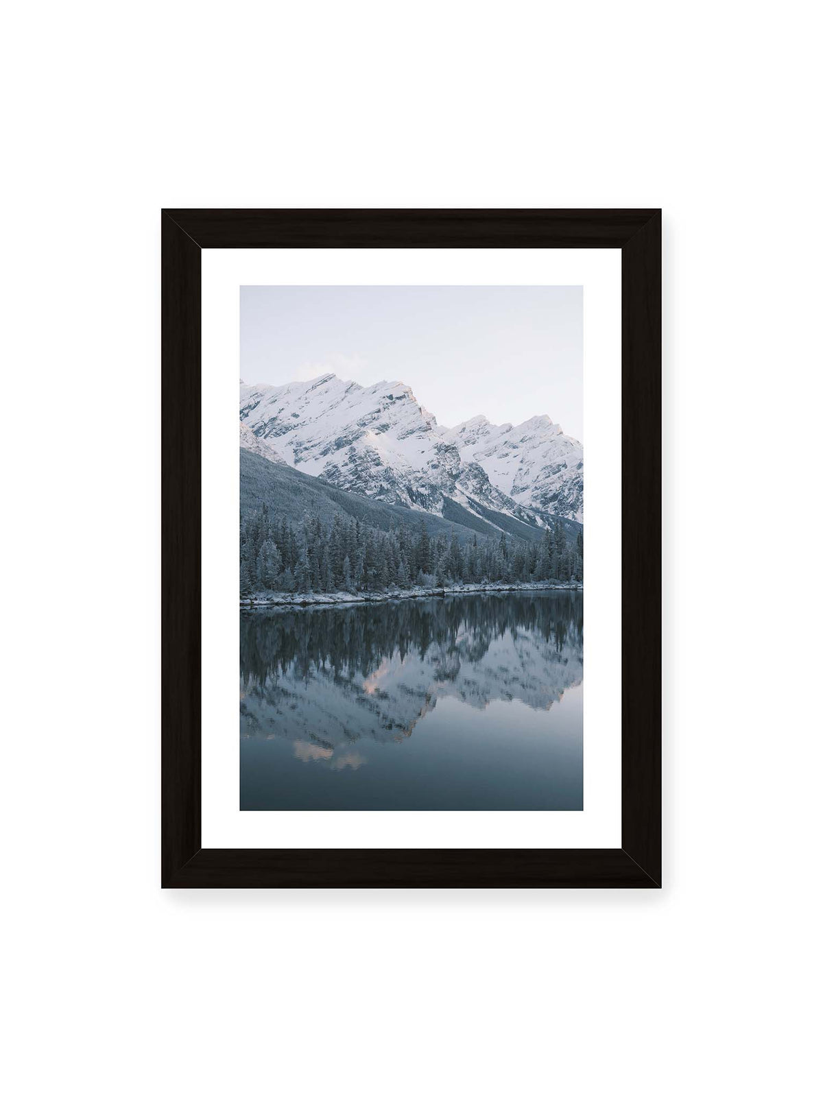 21x30 cm, weißer Galerie-Rand, schwarzer Rahmen – Verschneite Berggipfel und dichter Nadelwald spiegeln sich in einem ruhigen, blaugrauen See.