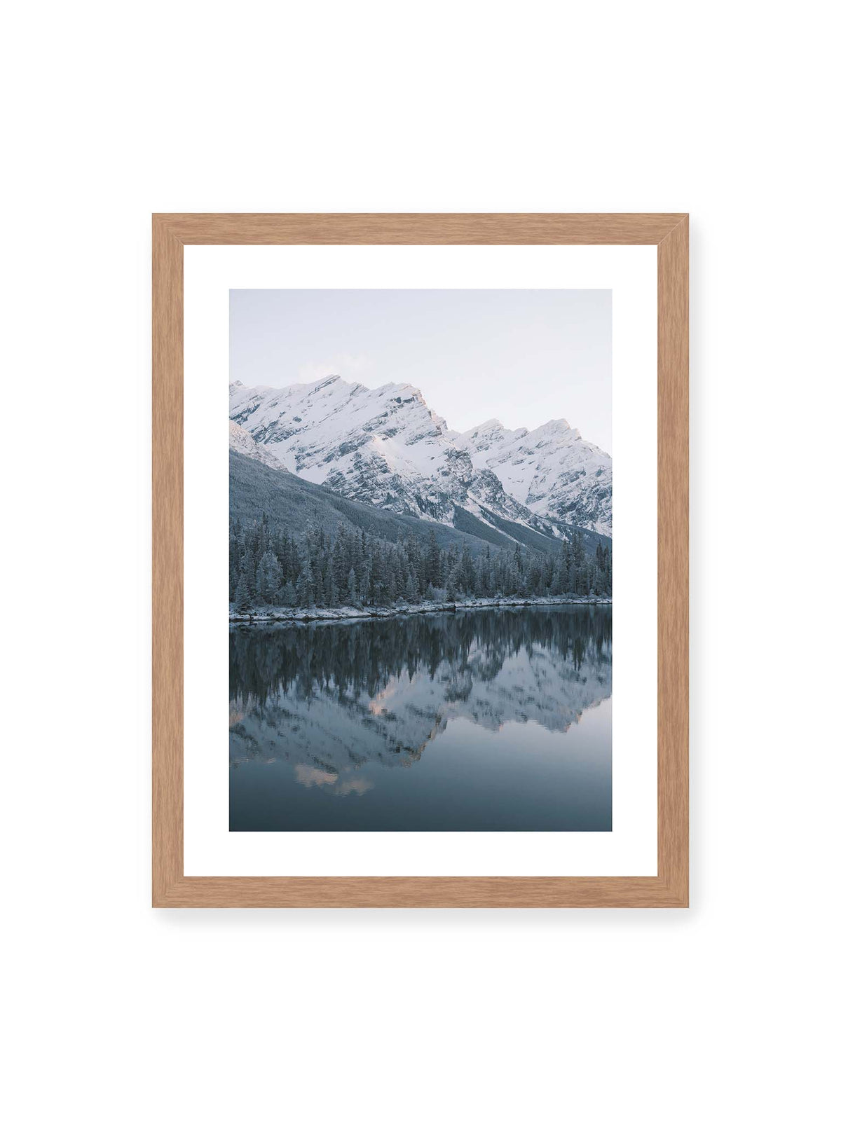 30x40 cm, weißer Galerie-Rand, Eichenrahmen – Verschneite Berggipfel und dichter Nadelwald spiegeln sich in einem ruhigen, blaugrauen See.