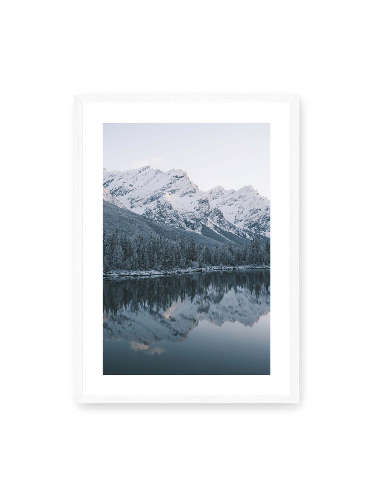 50x70 cm, weißer Galerie-Rand, weißer Rahmen – Verschneite Berggipfel und dichter Nadelwald spiegeln sich in einem ruhigen, blaugrauen See.