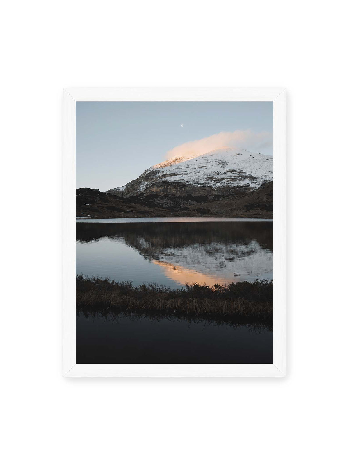 30x40 cm, weißer Rahmen – Verschneiter Bergrücken über dunklem Wasser mit rosa Wolke, Spiegelung und kleinem Mond am hellblauen Himmel.