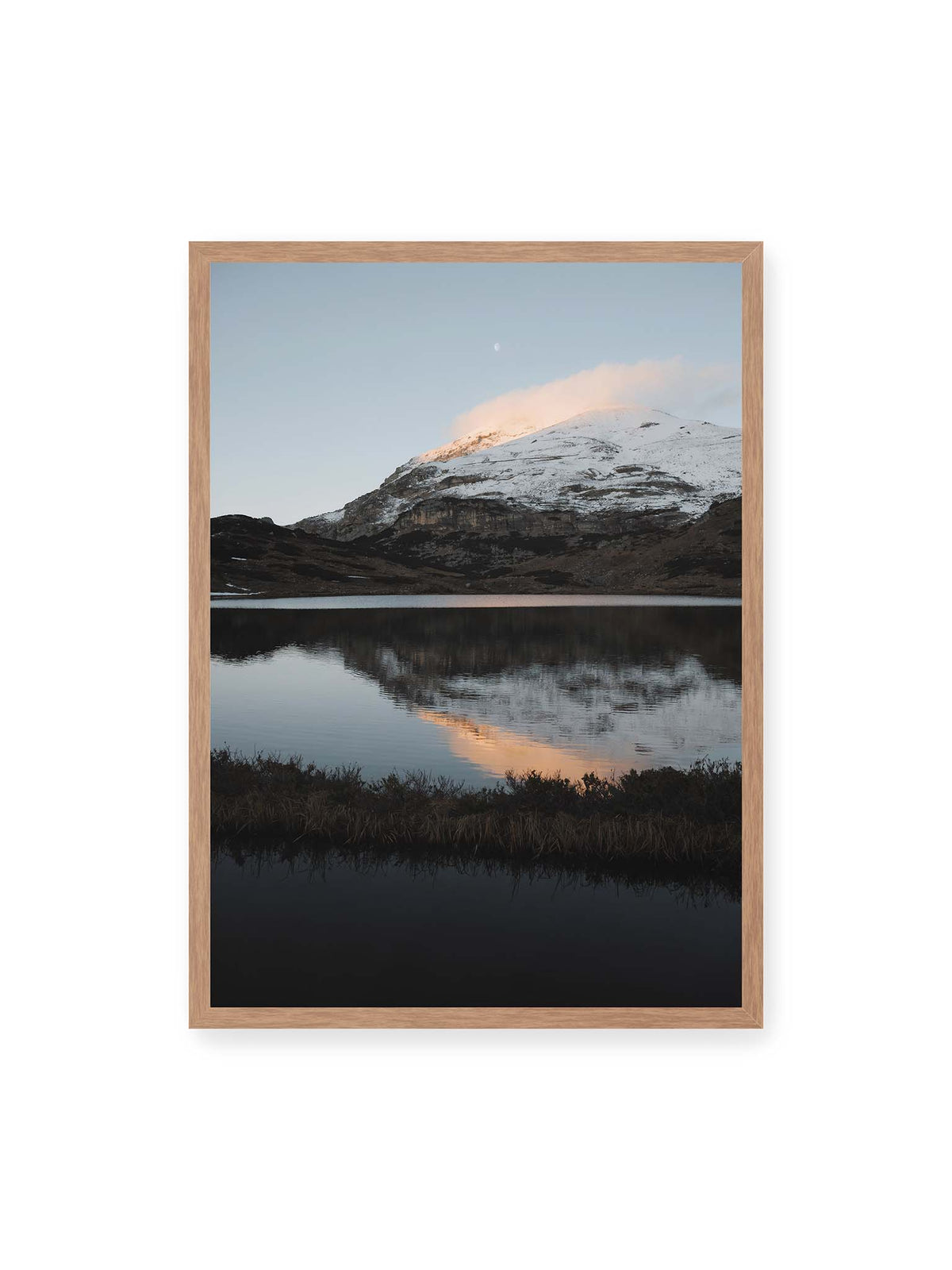50x70 cm, Eichenrahmen – Verschneiter Bergrücken über dunklem Wasser mit rosa Wolke, Spiegelung und kleinem Mond am hellblauen Himmel.