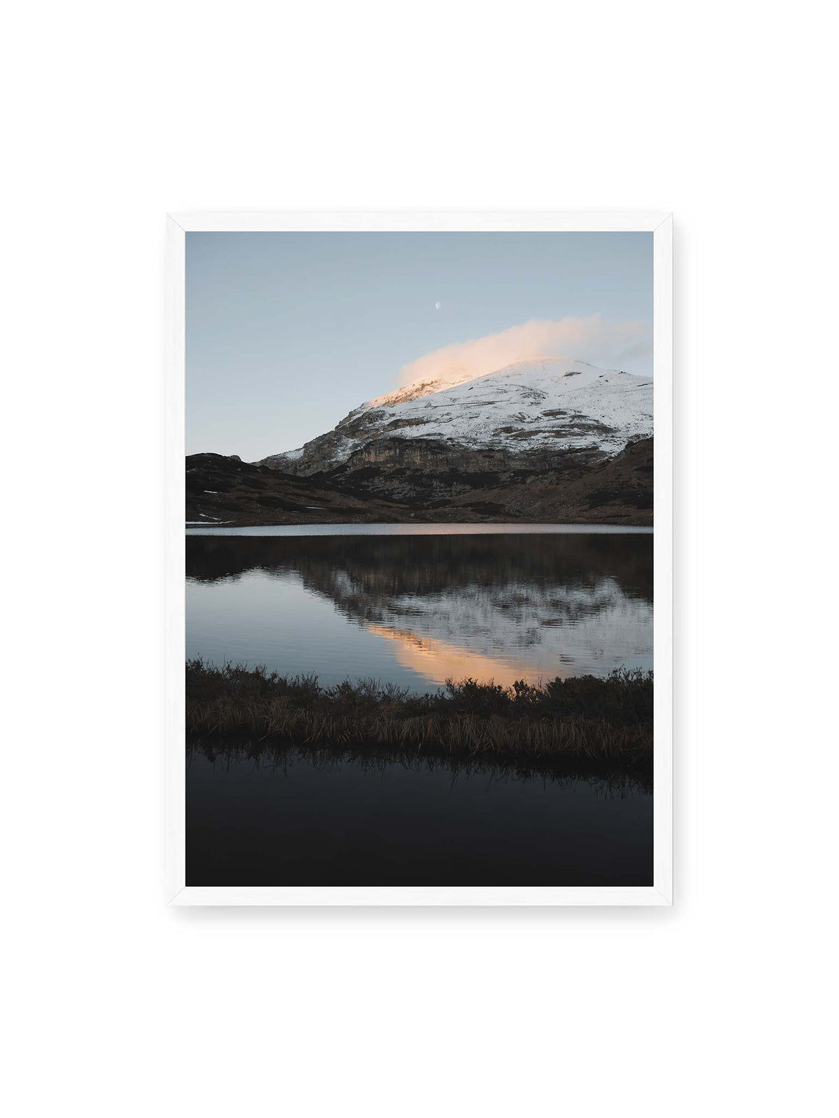 50x70 cm, weißer Rahmen – Verschneiter Bergrücken über dunklem Wasser mit rosa Wolke, Spiegelung und kleinem Mond am hellblauen Himmel.