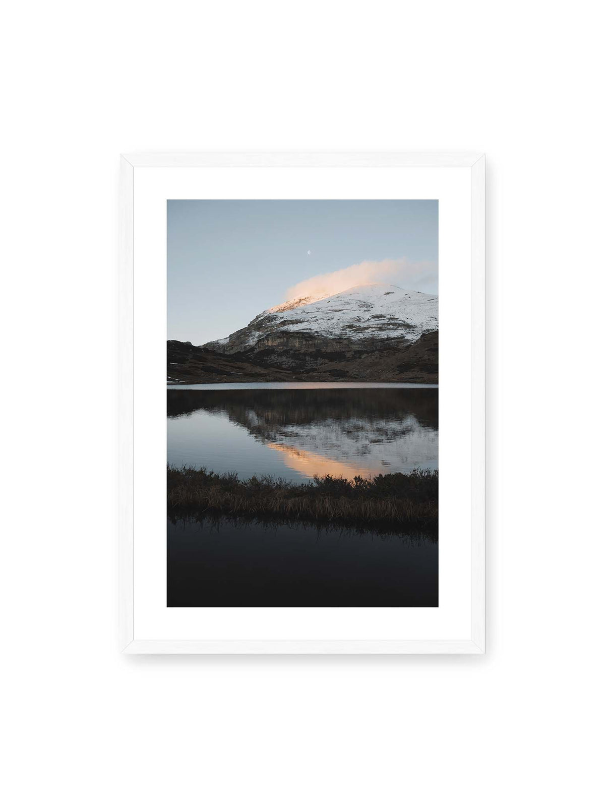 50x70 cm, weißer Galerie-Rand, weißer Rahmen – Verschneiter Bergrücken über dunklem Wasser mit rosa Wolke, Spiegelung und kleinem Mond am hellblauen Himmel.