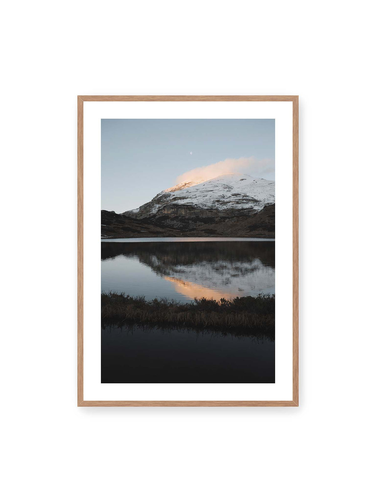 70x100 cm, weißer Galerie-Rand, Eichenrahmen – Verschneiter Bergrücken über dunklem Wasser mit rosa Wolke, Spiegelung und kleinem Mond am hellblauen Himmel.