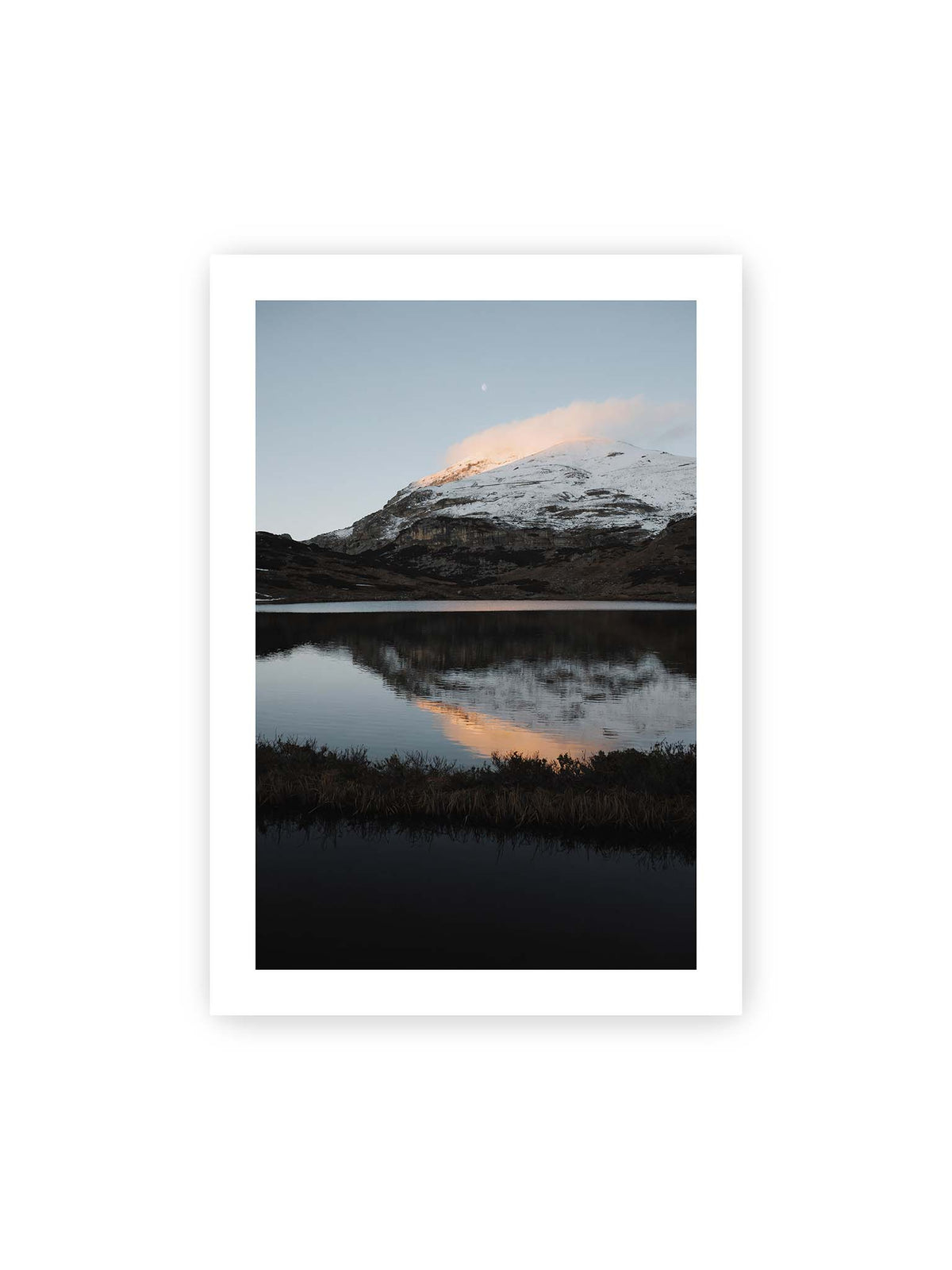 70x100 cm, weißer Galerie-Rand – Verschneiter Bergrücken über dunklem Wasser mit rosa Wolke, Spiegelung und kleinem Mond am hellblauen Himmel.