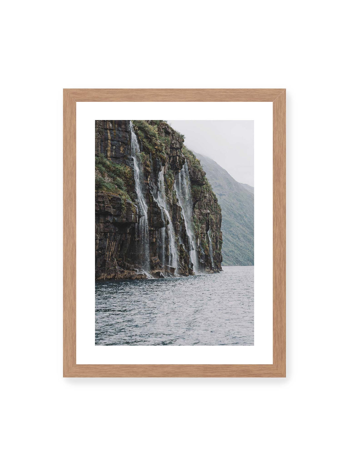 30x40 cm, weißer Galerie-Rand, Eichenrahmen – Mehrere Wasserfälle stürzen über eine dunkle, bewachsene Felswand direkt in eine weite Wasserfläche.