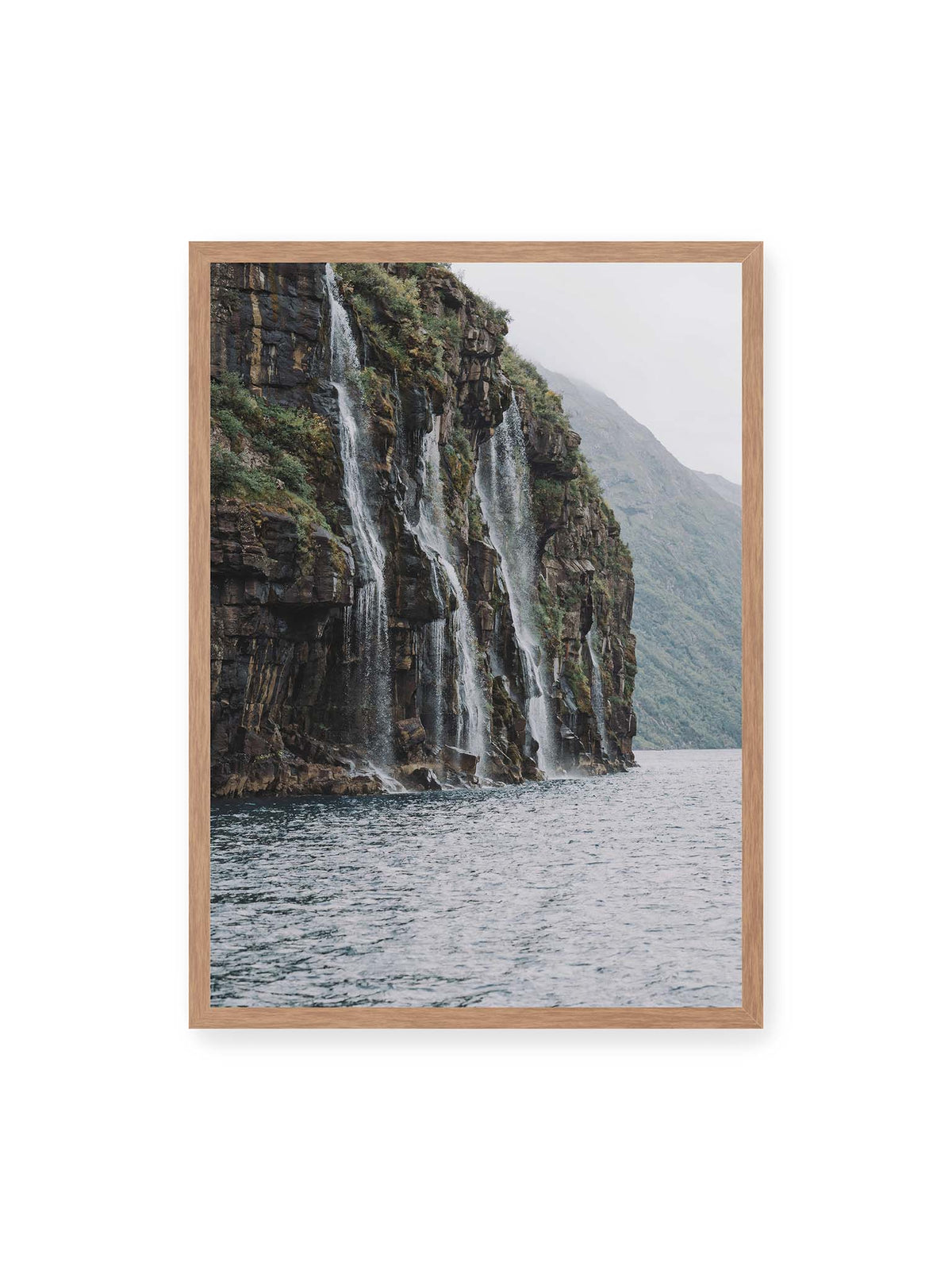 50x70 cm, Eichenrahmen – Mehrere Wasserfälle stürzen über eine dunkle, bewachsene Felswand direkt in eine weite Wasserfläche.