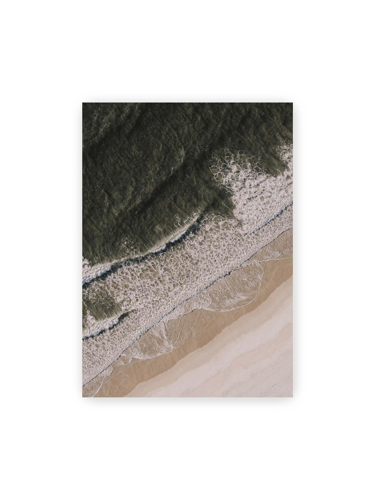 50x70 cm – Luftaufnahme einer Küstenlinie mit dunklem Meer, weißer Gischt und hellem Sand in diagonaler Komposition.