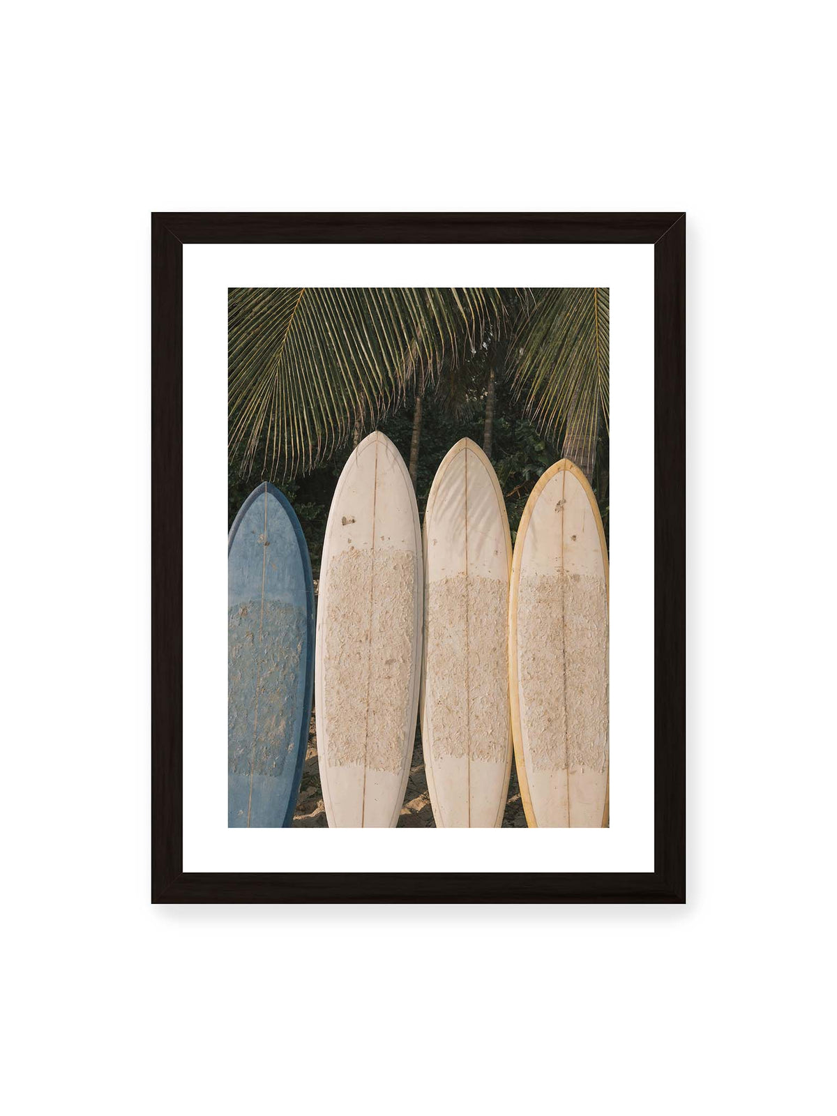 30x40 cm, weißer Galerie-Rand, schwarzer Rahmen – Vier aufrecht stehende Surfbretter mit Wachsresten unter langen Palmwedeln vor dichter grüner Vegetation.