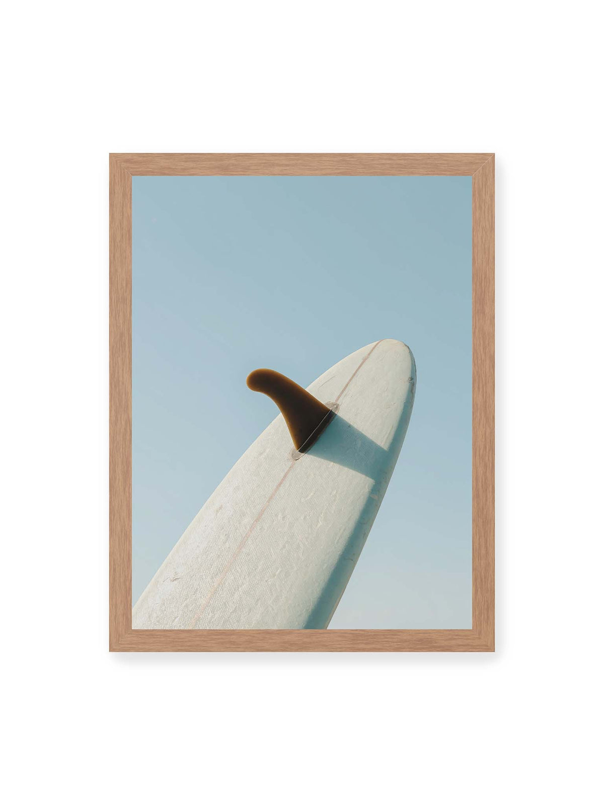30x40 cm, Eichenrahmen – Helles Surfbrett mit dunkler Finne und markantem Schatten ragt diagonal vor einen klaren blauen Himmel.