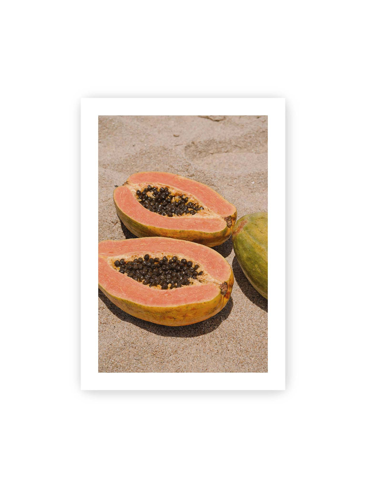 70x100 cm, weißer Galerie-Rand – Zwei geöffnete Papayahälften mit dunklen Samen und eine ganze Papaya auf hellem Sand.
