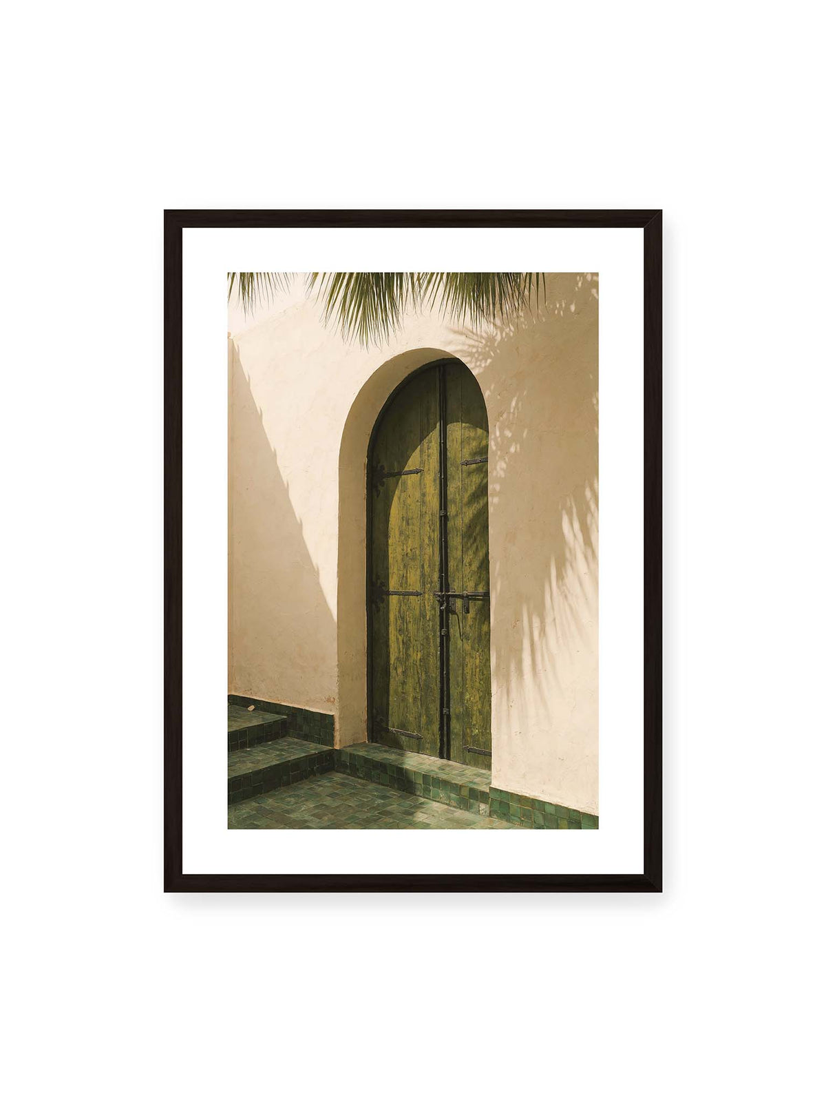 50x70 cm, weißer Galerie-Rand, schwarzer Rahmen – Grüne Holztür in einem Rundbogen mit Palmwedelschatten auf heller Wand und grünen Fliesen.